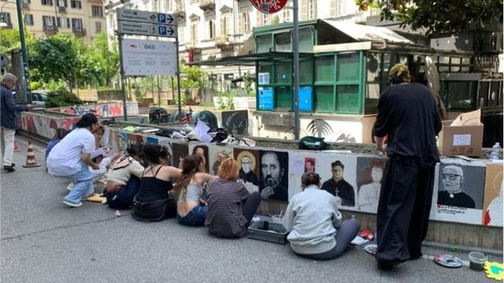 Sul muretto del Quadrilateroi santi parlano di solidarietà con i “laici” del quartiere