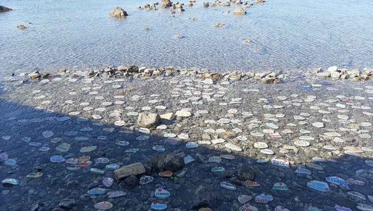 Nomi e cuori colorati sui sassi in acqua la Spoon river di Mario nel mare di Antignano