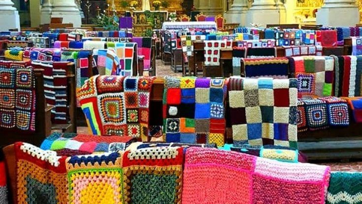 Parma, le coperte delle ricamatrici volontarie colorano la chiesa 
