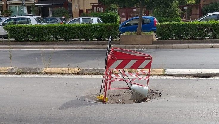 Via Croce Rossa, la transenna sprofonda nella buca sulla strada 