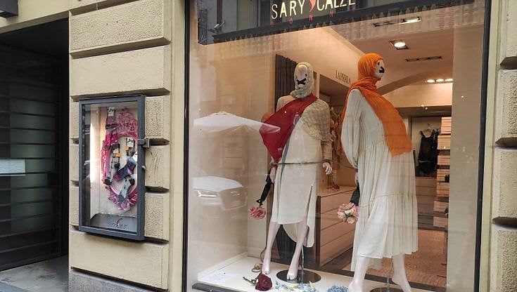 Velo, bocche tappate e un fiore nel fucile: la vetrina per le donne afghane nel centro di Torino