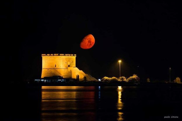Salento, un'enorme luna rossa illumina la torre