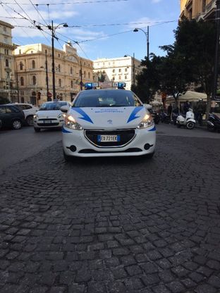 Auto dei vigili a guardia di una buca stradale in via Depretis a Napoli