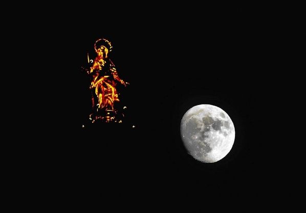 Sul Duomo giochi di luce tra la luna e la madonnina