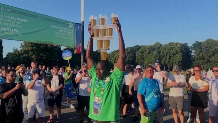 Euro 2024, con nove pinte di birra in equilibrio sulla testa il volontario giocoliere fa divertire i tifosi