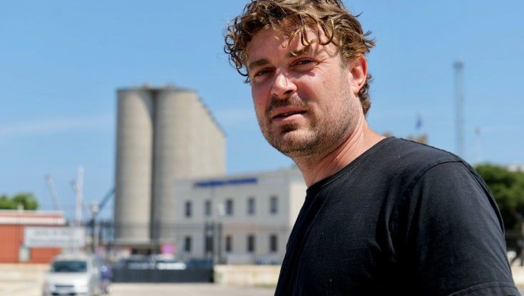 L'artista australiano Guido van Helten a Bari per colorare i silos del porto: murale di 32 metri nel segno di San Nicola. "Ci lavorerò due mesi"