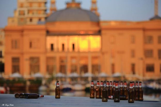Bari, il risveglio dopo la movida: le bottiglie di birra in fila sul lungomare