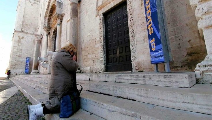 Furto a San Nicola, donna ucraina si inginocchia e piange davanti alle porte chiuse della Basilica: "Da Napoli per pregare per mia figlia, scomparsa a Mariupol"