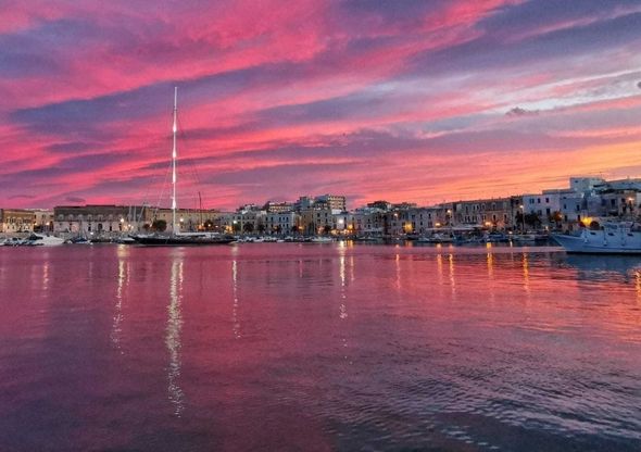 Trani, visto dal porto il tramonto rosa è come un quadro
