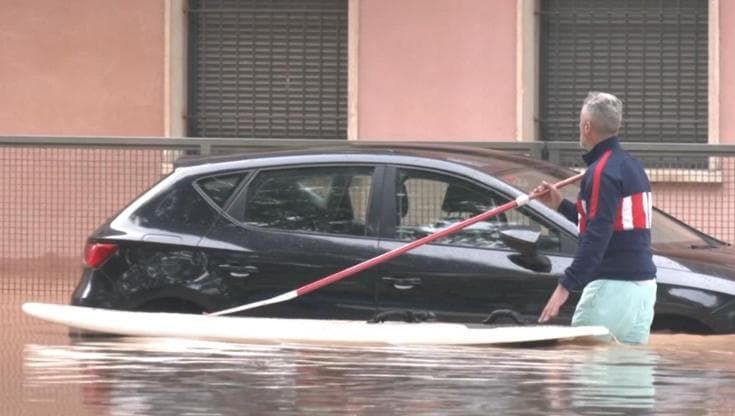 Catalogna, auto sommerse per l'inondazione: alcune persone usano tavole da sup nelle strade allagate