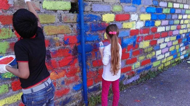 Roma, in via Soriso genitori e figli colorano i muri della scuola
