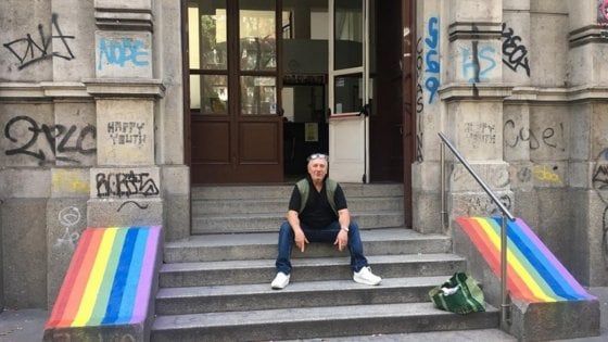 Milano, il prof copre con la bandiera arcobaleno le scritte fasciste sulle scale della scuola