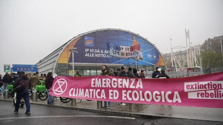 Ambientalisti per il clima si arrampicano su Porta Susa e srotolano lo striscione “1,5°C di ritardo”