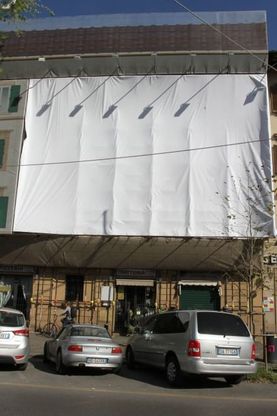Il cartellone troppo grande di Giani oscurato dal telo bianco
