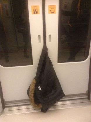 Milano, la porta del metrò si mangia il piumino: operazione recupero
