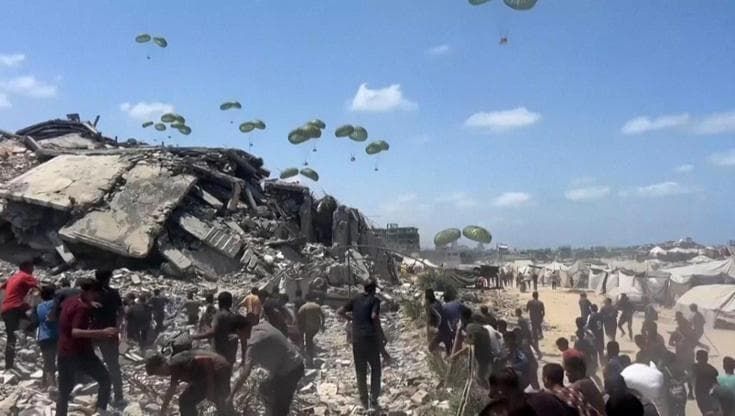 Gaza, gli aiuti lanciati dagli aerei sul nord della Striscia: la corsa per riuscire a prendere cibo