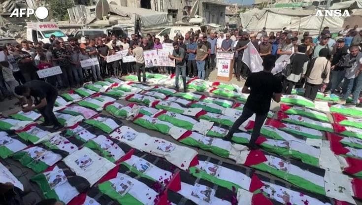 Gaza, funerale di massa per 100 vittime estratte dalle macerie: i corpi nelle bandiere palestinesi