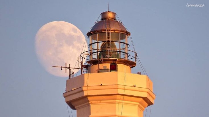 Salento, dietro al faro spunta una luna gigante