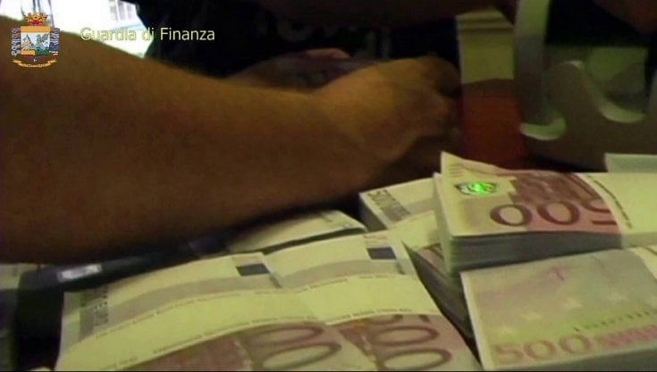 La soffiata: "In quella palazzina ci sono armi". Ma la Gdf trova 460mila euro in contanti e un laboratorio per criptovalute. La pista dei clan
