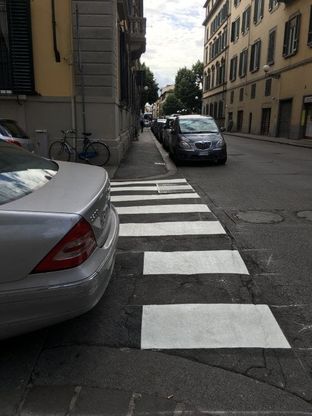 Firenze, l'auto è parcheggiata male: le strisce pedonali sono dipinte a metà