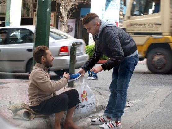 Foto simbolo, la crisi greca e la solidarietà: regala le scarpe a un senzatetto scalzo