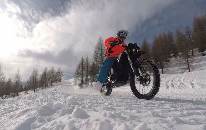 Con la moto su dalla pista di discesa libera